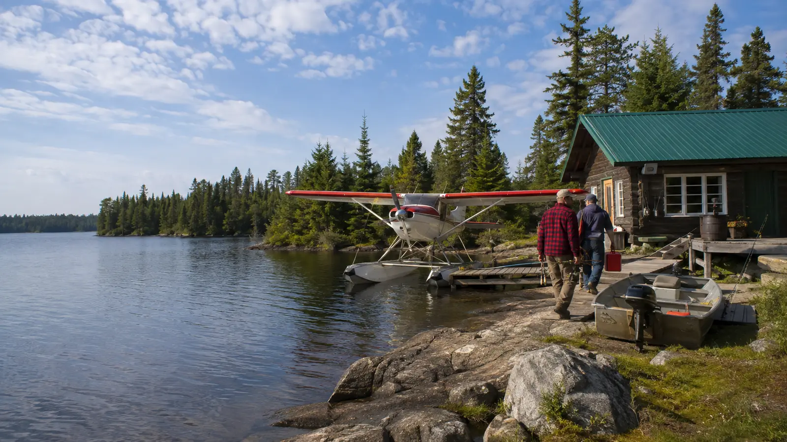 Two anglers travel across a wide Northwestern Ontario lake between forested islands.